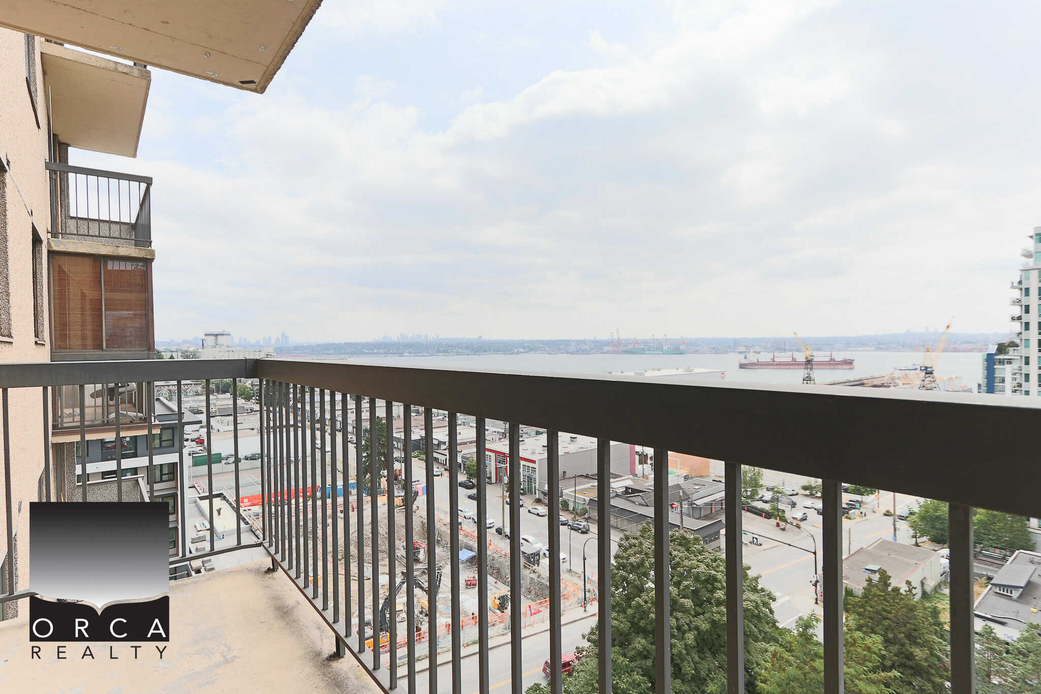 Panoramic balcony view of Vancouver waterfront and city skyline from downtown high-rise condo in Vancouver, BC. Perfect for real estate listings showcasing Vancouver properties with ocean and city views.