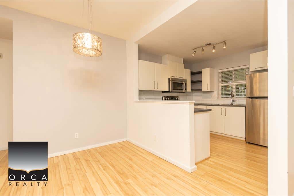 Bright modern kitchen with stainless steel appliances and white cabinetry, open-concept living space, perfect for Vancouver Island homebuyers seeking stylish, functional homes.