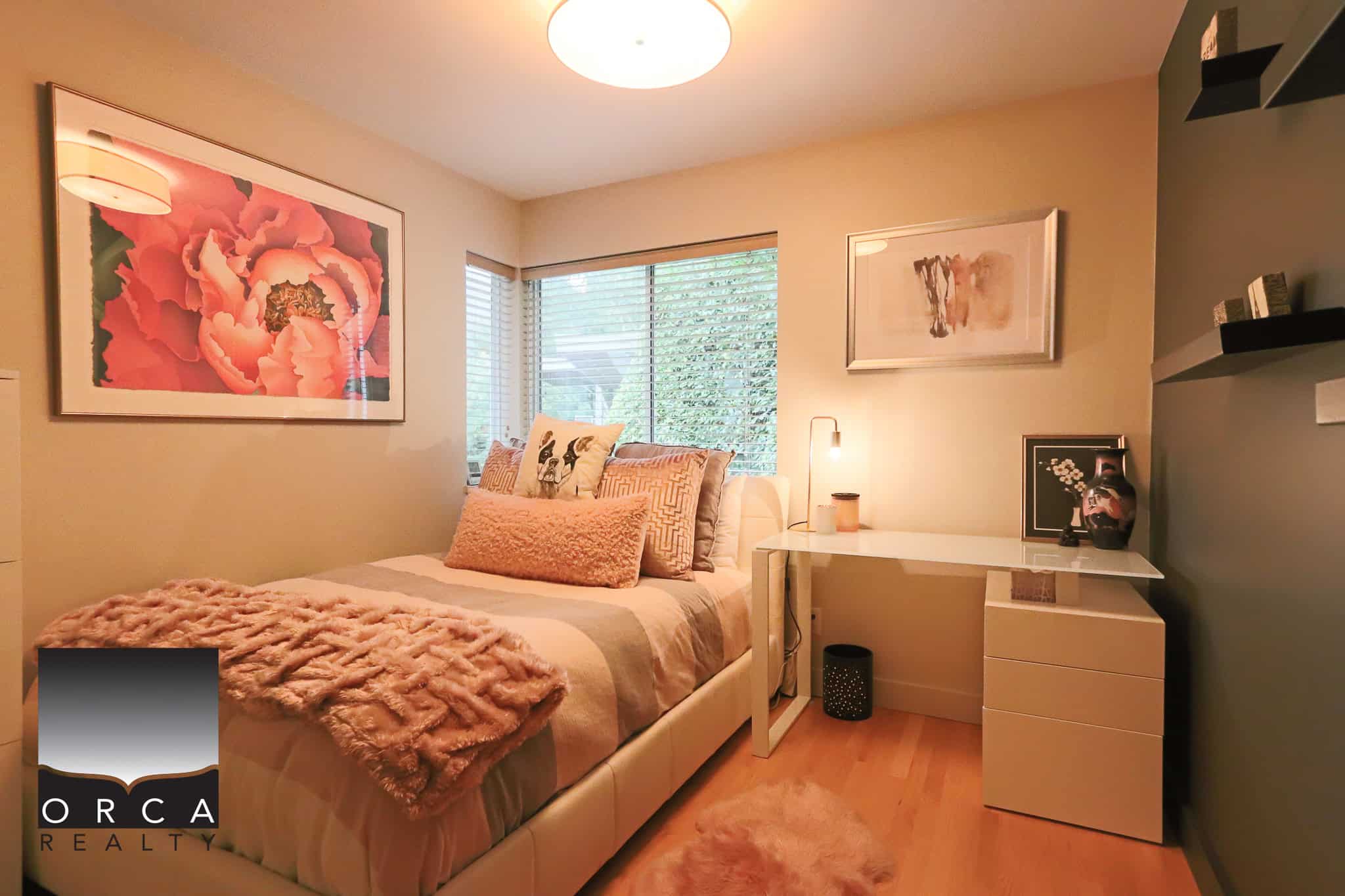 Cozy bedroom with soft lighting, modern decor, large window with blinds, and decorative pillows, ideal for relaxing and comfort. Perfect for homebuyers seeking stylish, inviting interior spaces in Victoria.