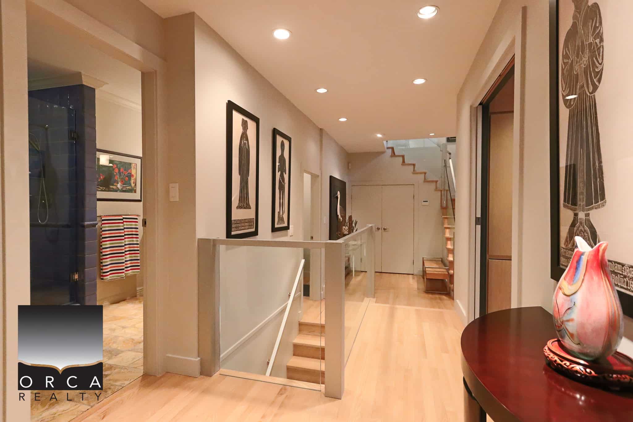 Spacious modern home interior with stylish artwork and hardwood floors, showcasing luxury real estate listings by Orca Realty Inc. in Vancouver.