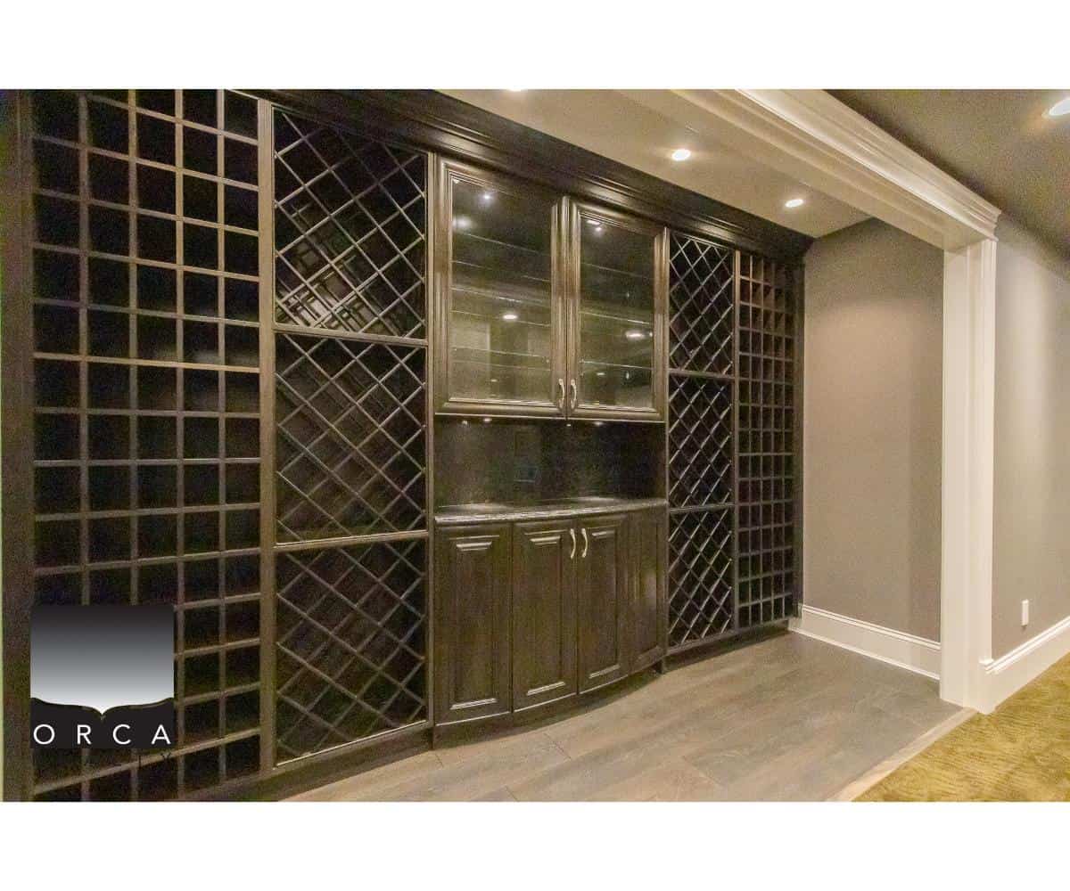 Spacious custom wine cellar with dark wooden wine racks, glass-front cabinetry, and elegant molding, perfect for wine storage and display, located in a luxury Vancouver home.