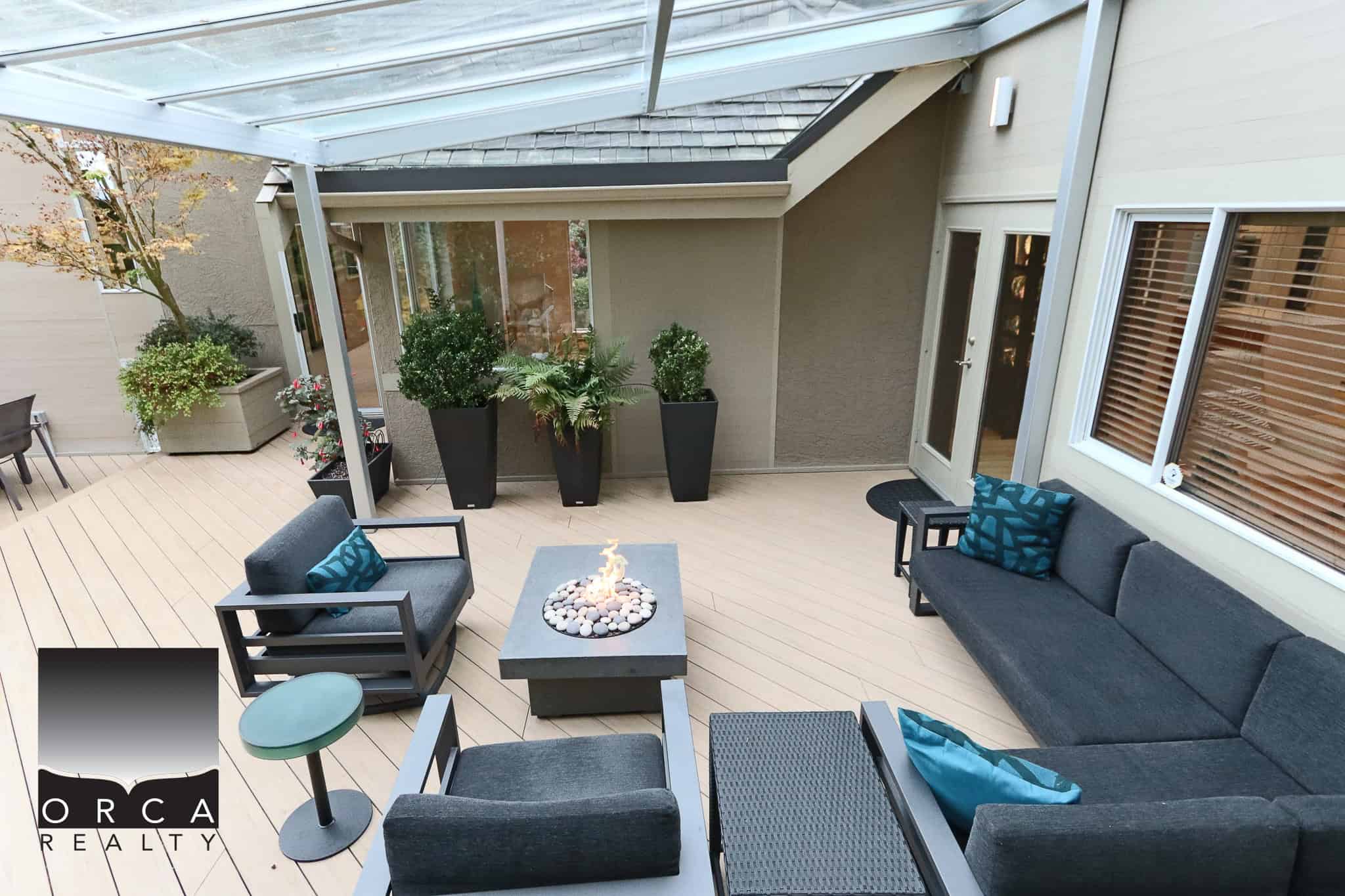 Modern outdoor patio with comfortable seating, fire pit, and decorative plants, perfect for relaxing or entertaining; designed to enhance residential home living and outdoor enjoyment.