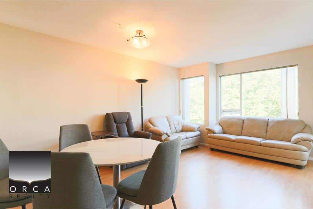 Spacious living room with large windows, modern furniture, and natural light, ideal for Vancouver real estate buyers seeking comfort and style. Perfect for family living or entertaining guests.