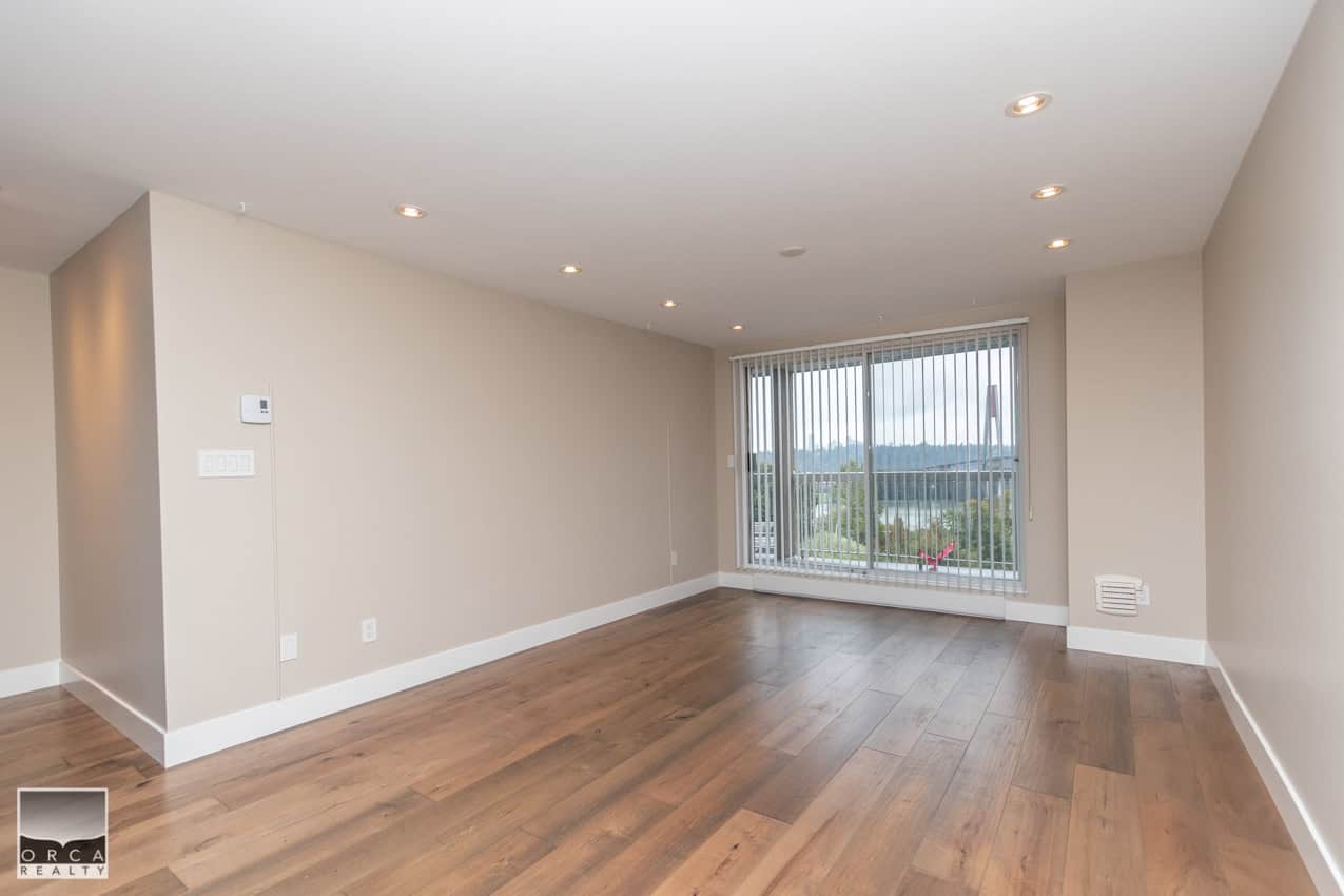 Bright living room with large window views and hardwood flooring, perfect for Vancouver homebuyers. Modern interior space showcasing ORCA Realty Inc. property listing.