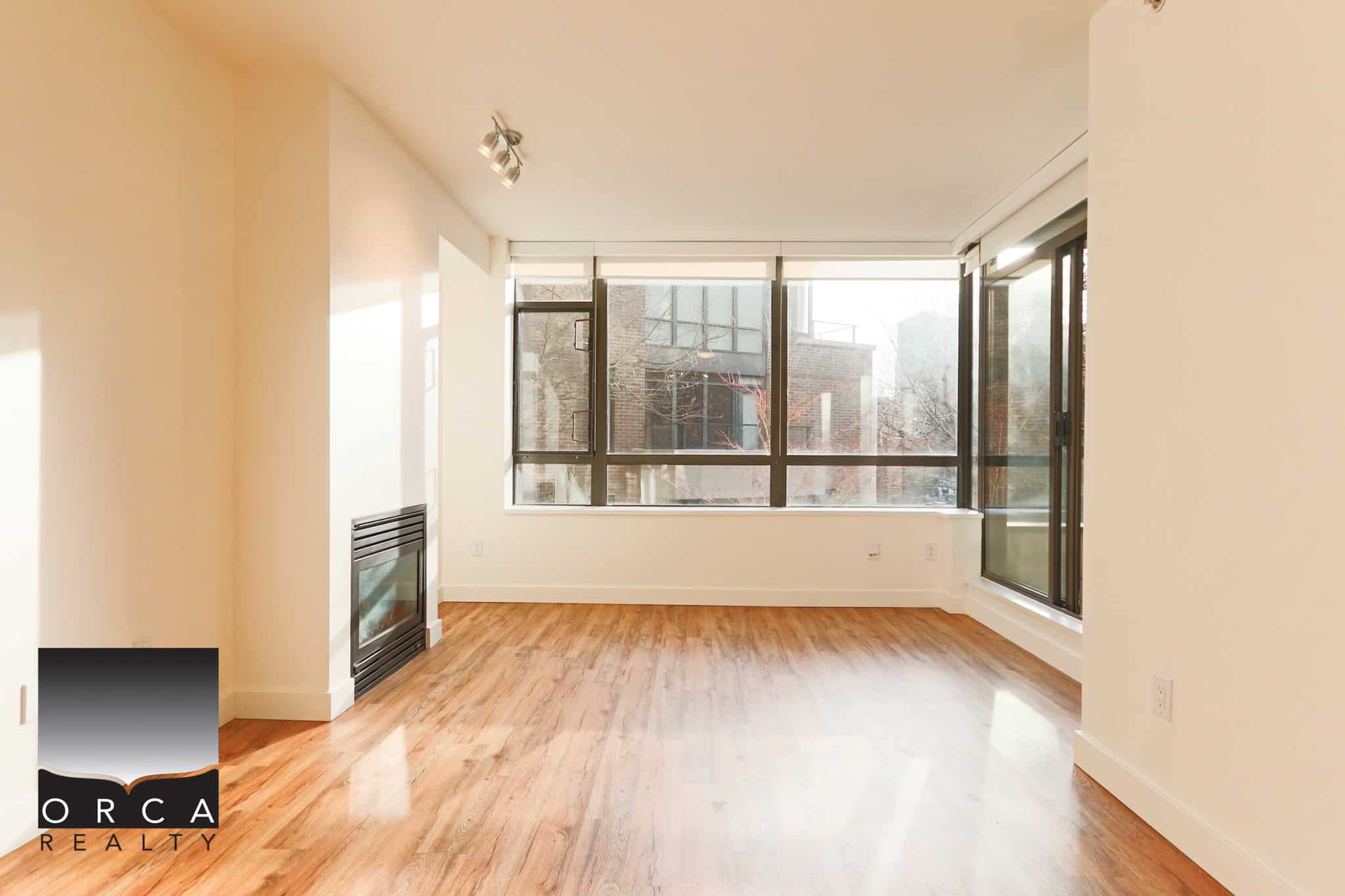 Bright North Vancouver apartment with large windows and hardwood floors.