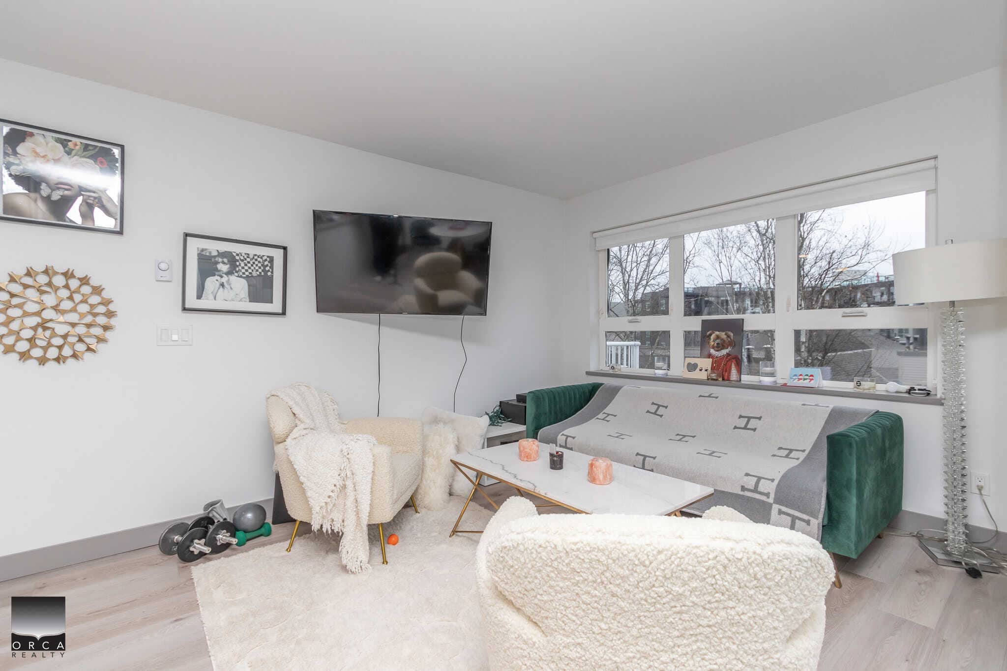 Cozy living room with modern decor, large windows, and minimalist furniture perfect for urban living in Vancouver, BC. Ideal for showcasing Orca Realty Inc. properties.