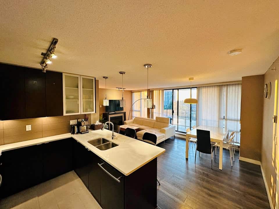 Bright modern open-concept kitchen and living room in a Vancouver downtown apartment, featuring sleek cabinetry, ample natural light, and contemporary furnishings.
