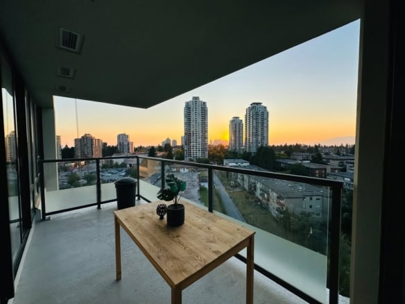 Spacious balcony with city skyline view in a modern Vancouver apartment, perfect for enjoying sunsets and urban living, managed by Orca Realty Inc.