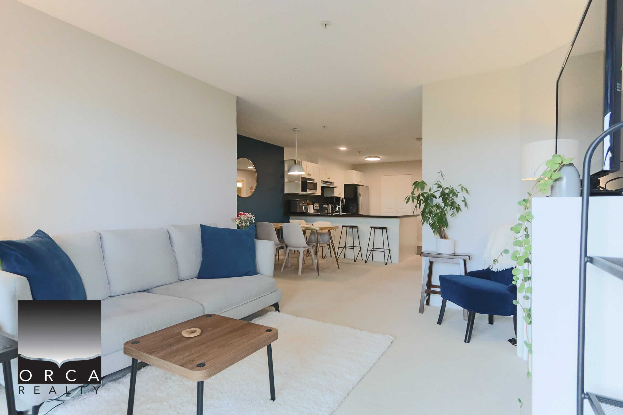 Modern open-concept living room and kitchen in a Vancouver apartment with stylish decor, bright natural light, and contemporary furnishings.