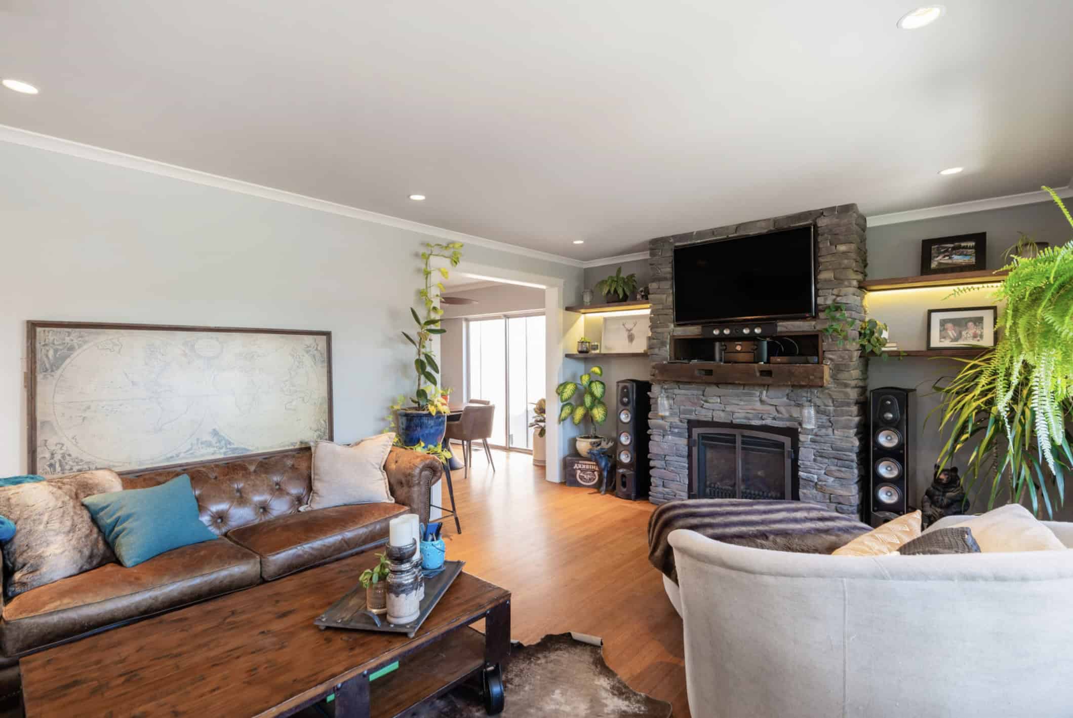 Screenshot Cozy living room with stone fireplace, modern entertainment center, and comfortable seating in a home listed by Orca Realty Inc. Vancouver Island real estate.