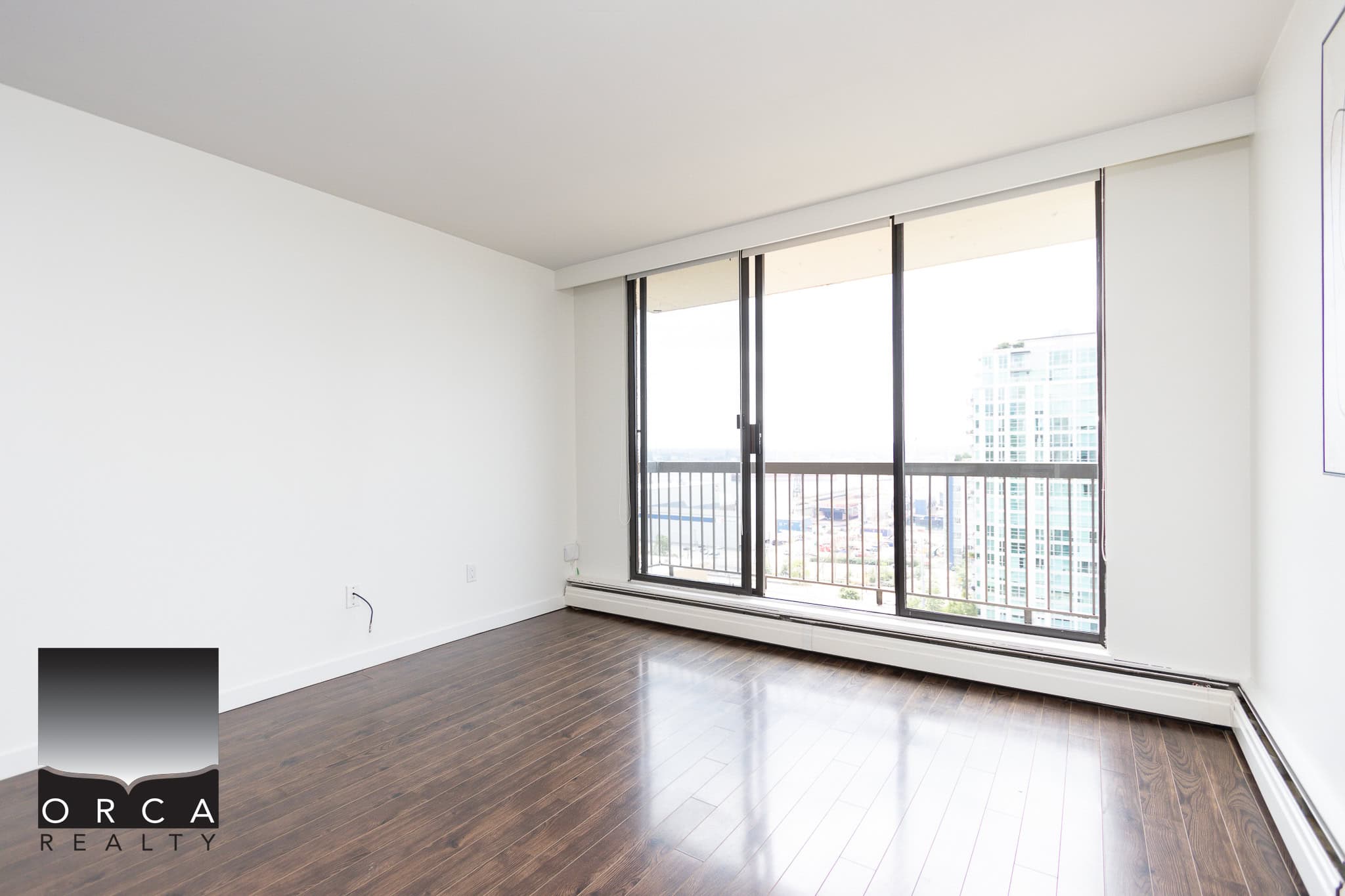 Spacious modern apartment living room with large windows, hardwood flooring, and city views, ideal for Vancouver real estate investments and rental opportunities.