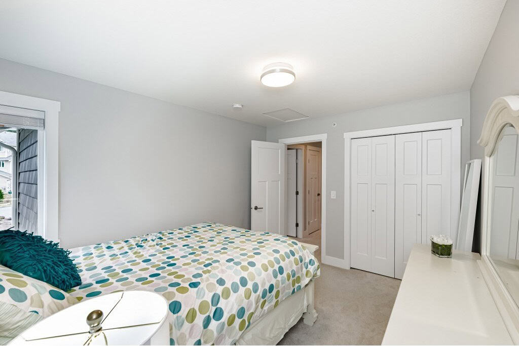 Bright and cozy bedroom in a modern home listed by Orca Realty Inc., featuring neutral decor, ample closet space, and natural light, perfect for comfortable living.