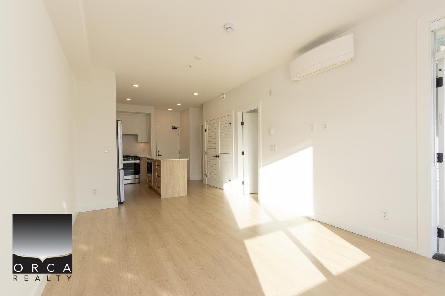 Bright open-concept living space with modern kitchen, natural light, hardwood floors, and fresh white walls, perfect for Vancouver area homebuyers.