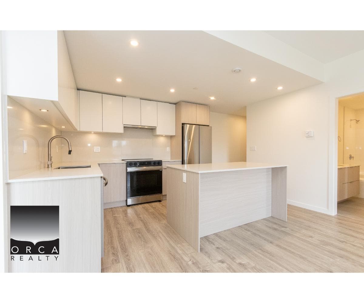 Contemporary kitchen with modern appliances, light wood cabinetry, and a spacious island, ideal for Vancouver Island homes; perfect for buyers seeking stylish, functional real estate.