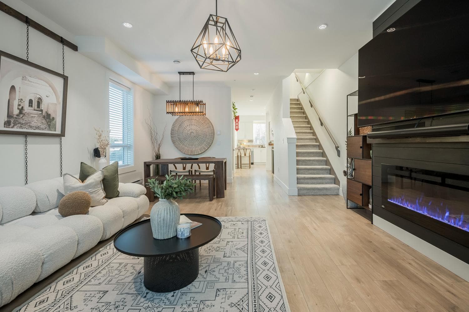Modern living room with fireplace and Scandinavian decor featuring a white sofa, wooden accents, and natural light, ideal for Vancouver homebuyers seeking a stylish, cozy home.