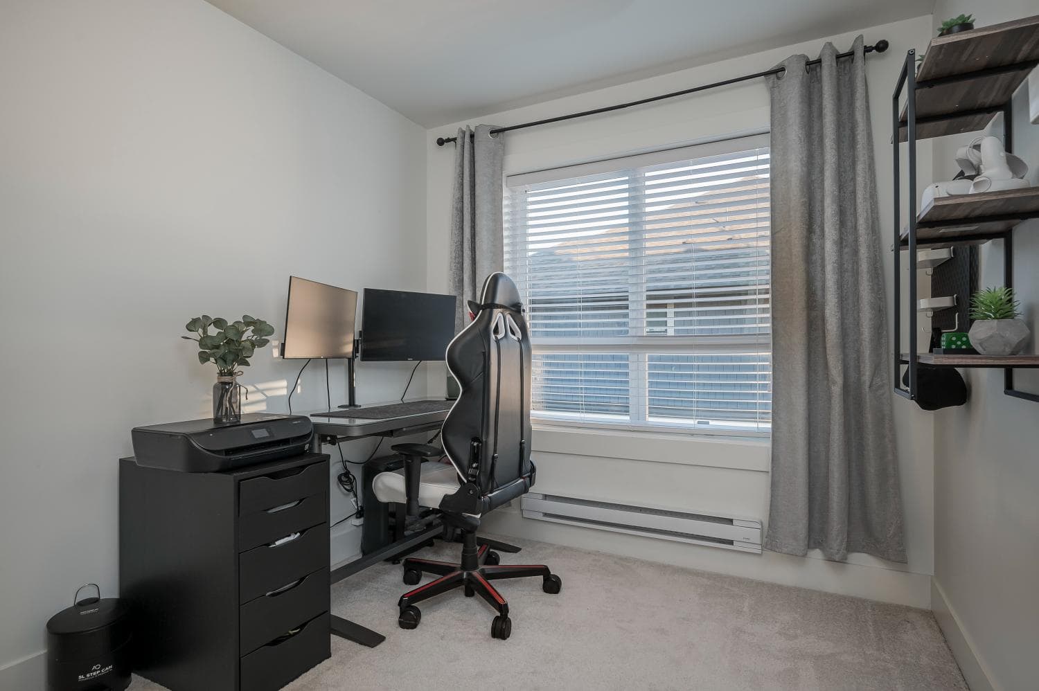 Modern home office setup with dual monitors, ergonomic chair, and organized shelving for a productive workspace in a Vancouver-area property.