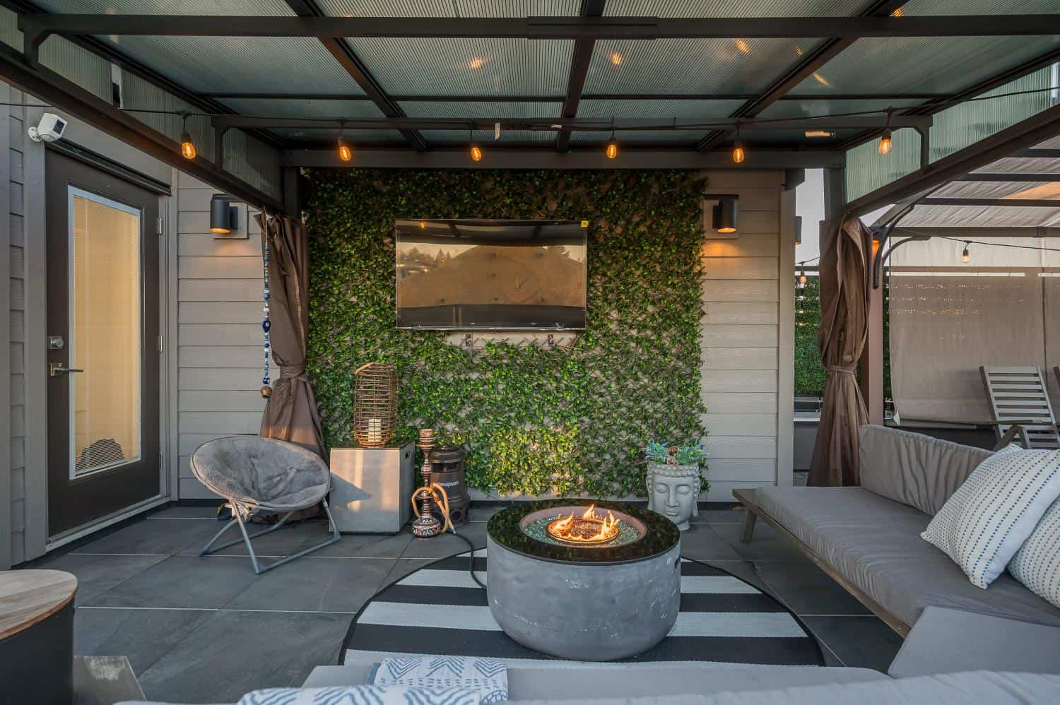 Cozy outdoor patio with a modern fire pit, comfortable seating, and decorative greenery, ideal for relaxing or entertaining at Orca Realty Inc. in Victoria, BC.