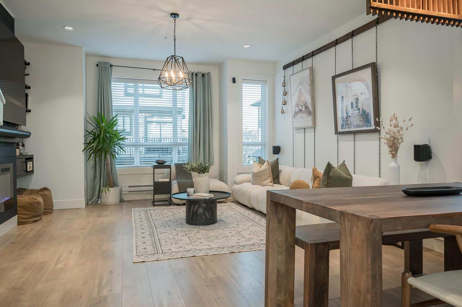 Modern living room with large windows, cozy seating, and contemporary decor in a Vancouver-area condo. Perfect for homebuyers seeking stylish, functional spaces in BC real estate.