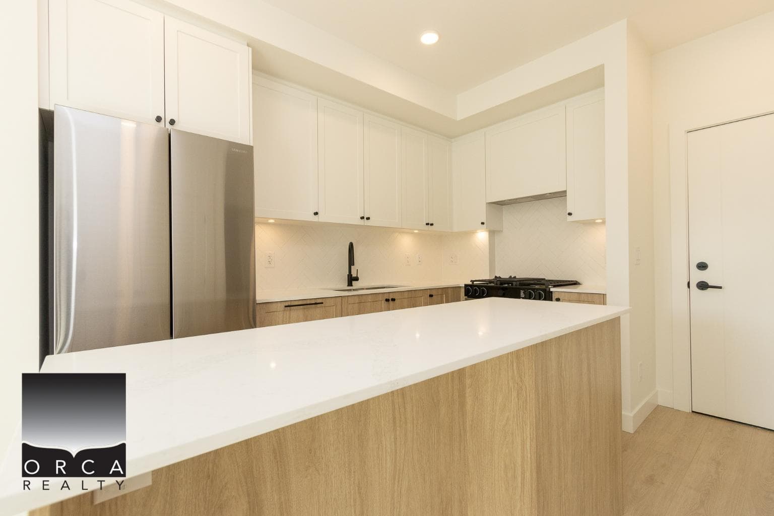 Bright modern kitchen with white cabinets, stainless steel appliances, and a spacious island, ideal for Vancouver island real estate listings and homebuyers seeking contemporary home design.