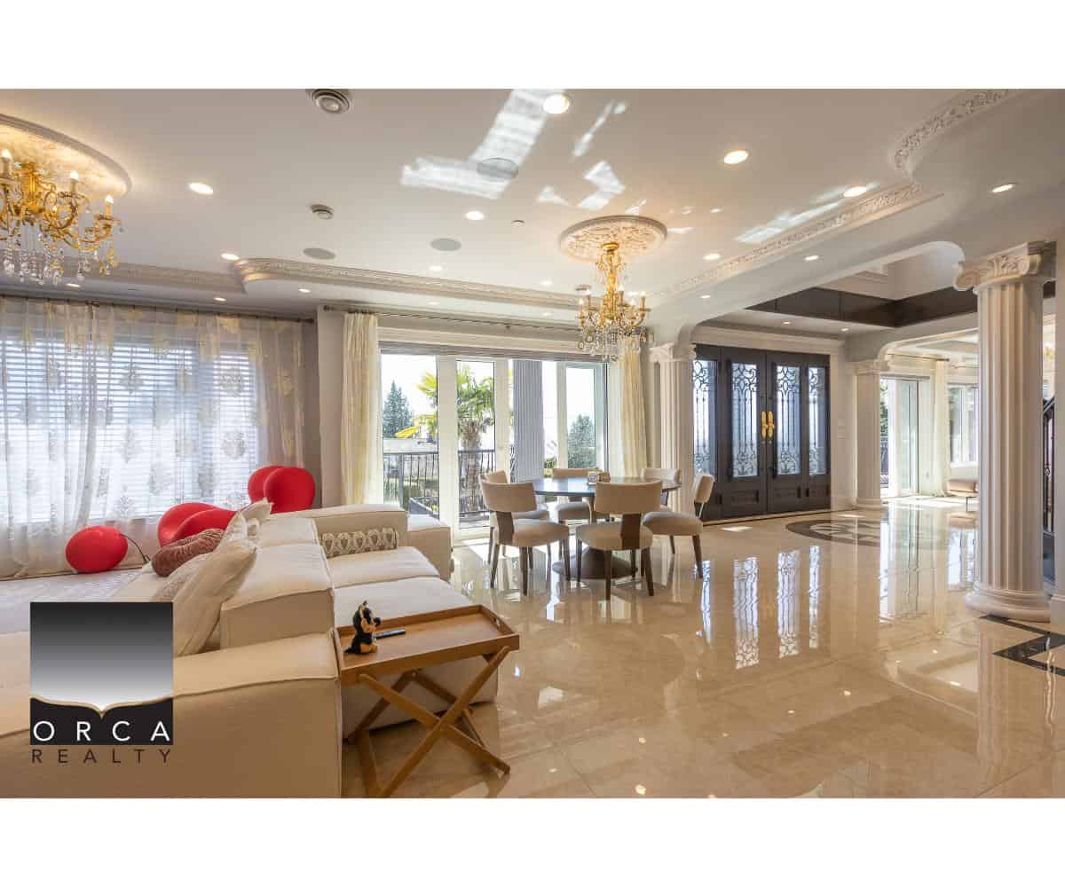 Luxurious living room with elegant chandeliers, classical columns, and large windows offering natural light, perfect for upscale real estate in Greater Toronto Area.