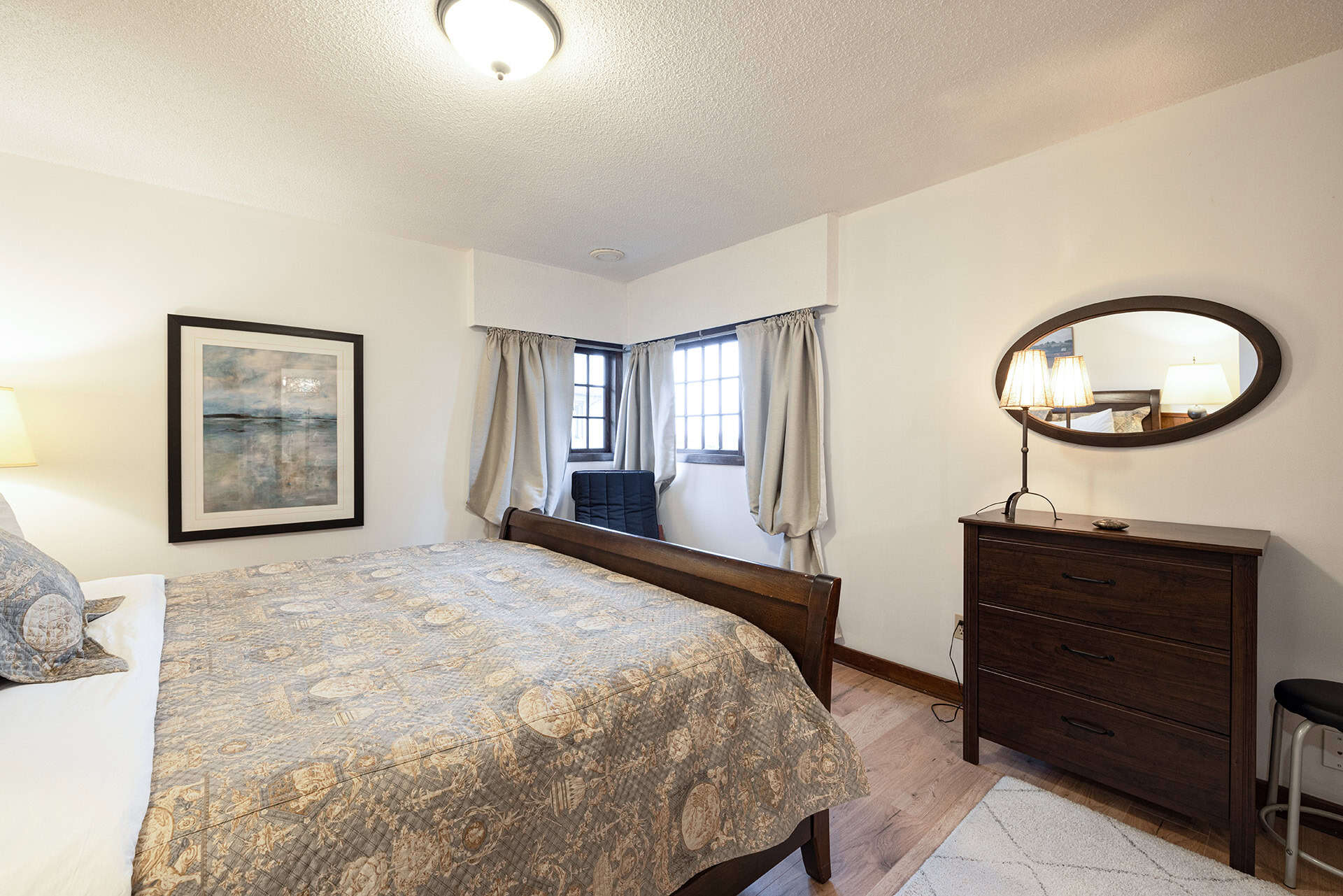 Cozy bedroom with natural light, wooden furniture, and elegant decor, showcasing Orca Realty Inc.'s premium property listings in Vancouver and BC, perfect for homebuyers.