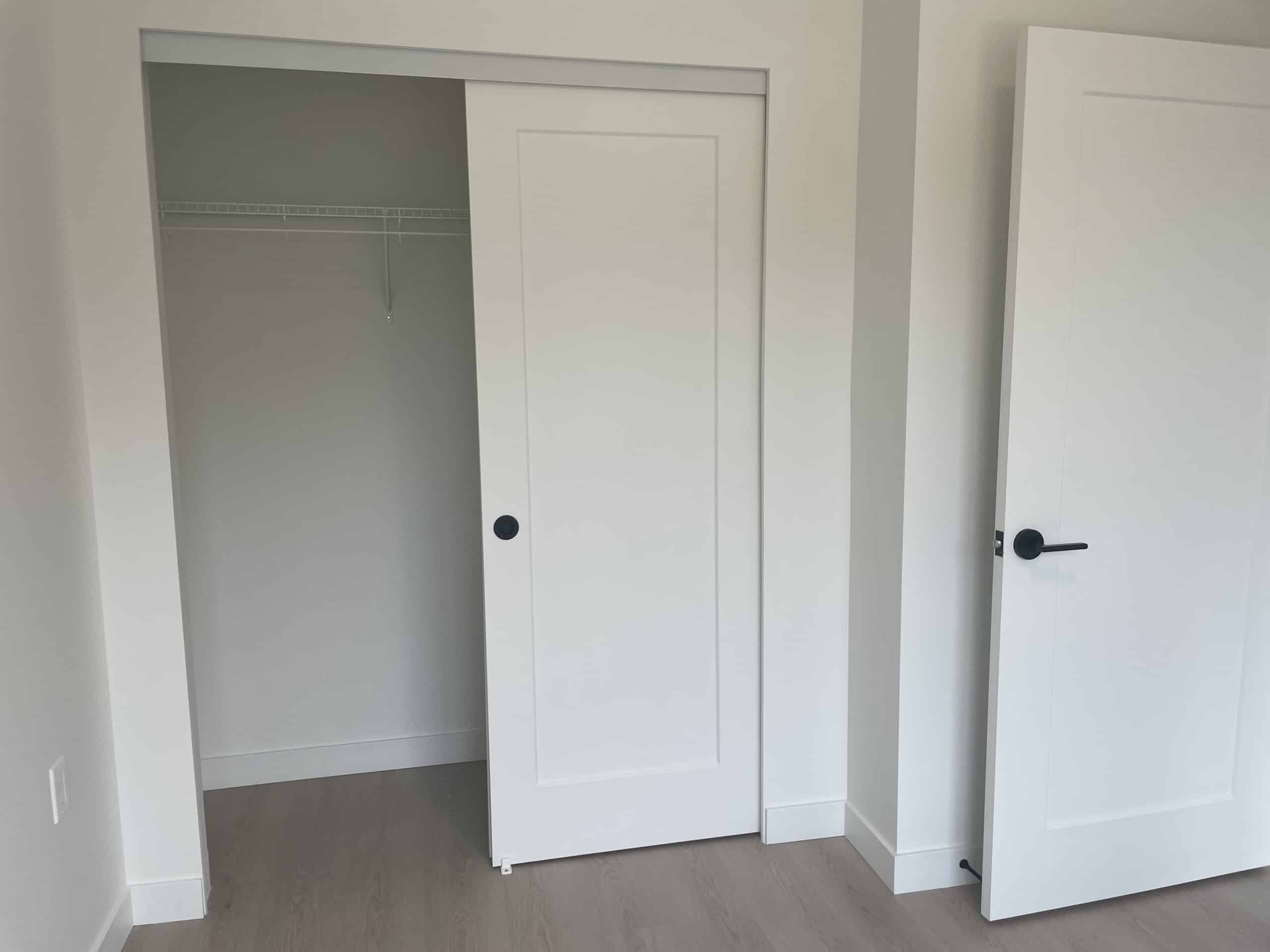 Modern white closet with sliding door and interior shelving for optimal storage solutions - ideal for Vancouver, BC homes.