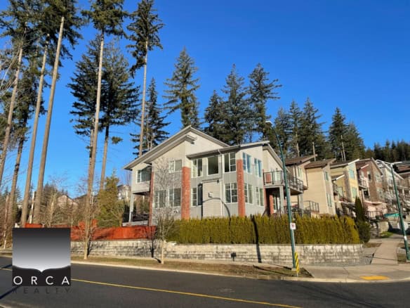 Modern multi-family residential buildings designed for comfort and style, nestled among tall evergreen trees on a landscaped street in a desirable neighbourhood.