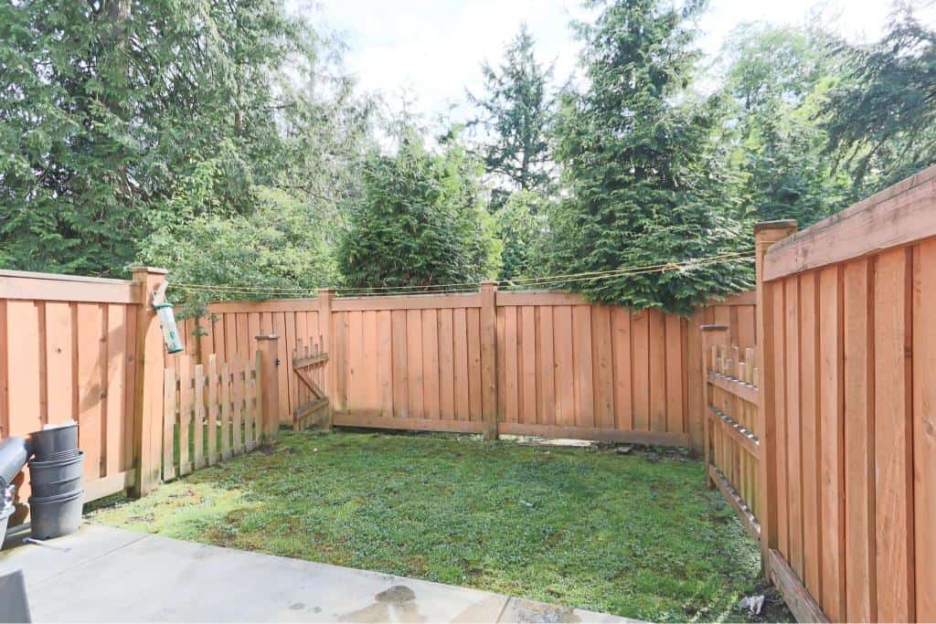Lush backyard enclosed with a wooden fence, ideal for outdoor activities and privacy, perfect for homeowners looking to enjoy outdoor living spaces in British Columbia.