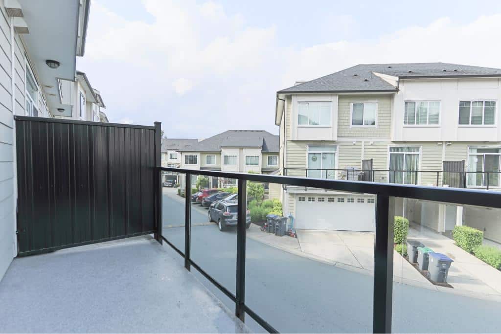 Spacious balcony view of modern townhouses and a quiet residential street, ideal for relaxing or outdoor gatherings in a family-friendly neighbourhood.