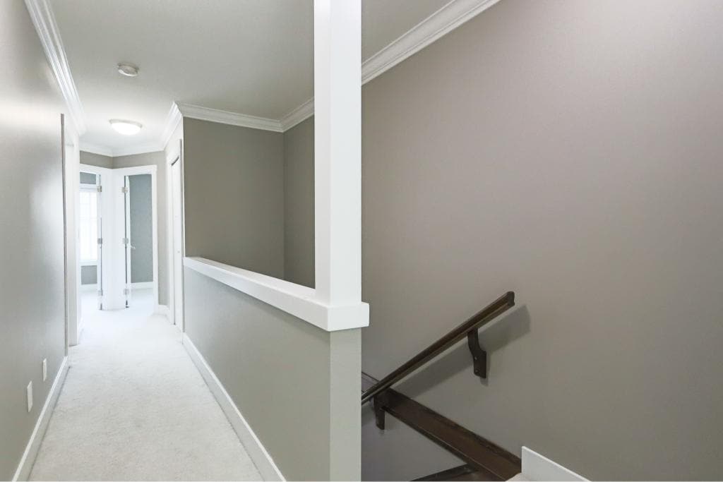 Bright interior view of a modern condo corridor showcasing neutral wall colours, crown molding, and natural light, ideal for Vancouver Island real estate listings.