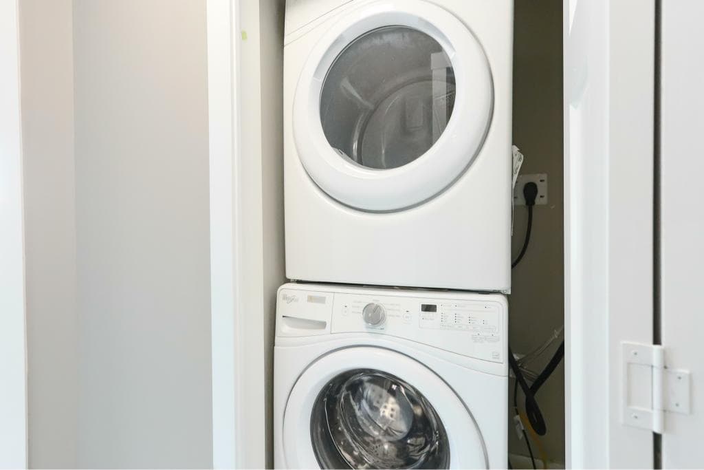 Washer and dryer stack in laundry closet.