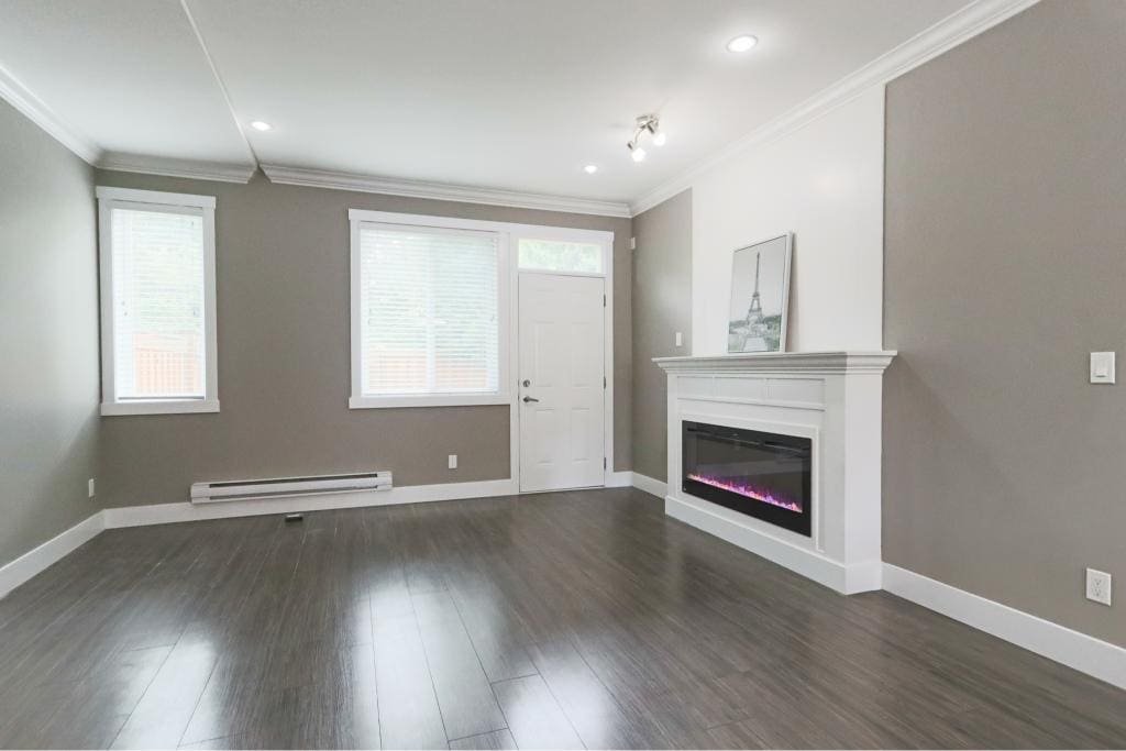 Bright modern living room with grey walls, white trim, hardwood floors, electric fireplace, and large windows in a property listed by Orca Realty Inc.