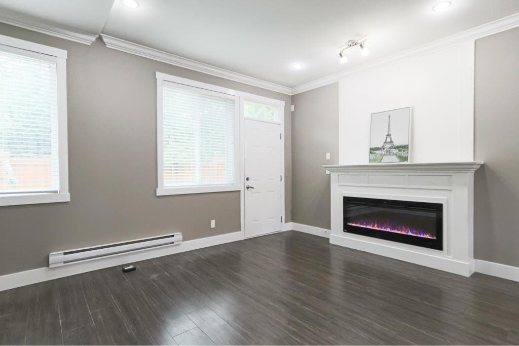 Bright living room with modern electric fireplace, grey walls, white trim, large windows, and hardwood flooring, ideal for comfortable home living.