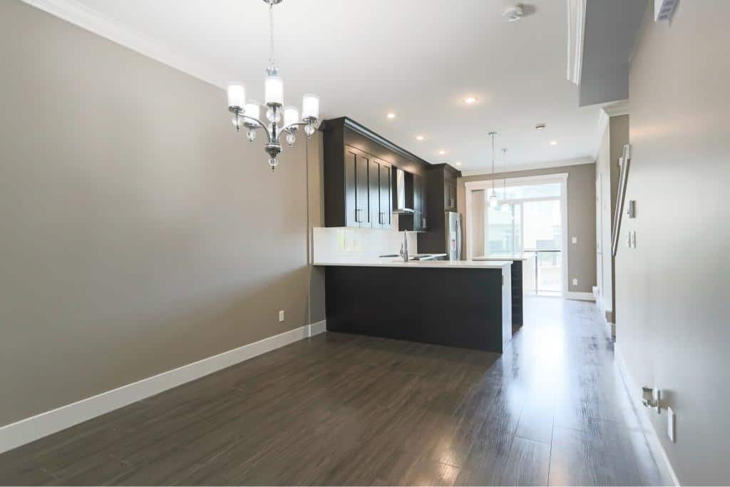 Modern open-concept kitchen with sleek black cabinetry and stainless steel appliances, perfect for contemporary living.