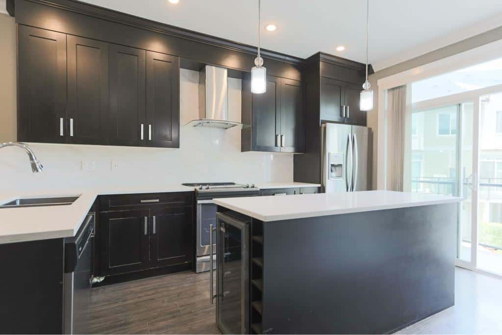 Modern kitchen with dark cabinetry, stainless steel appliances, and a spacious island, ideal for Vancouver real estate and property management.