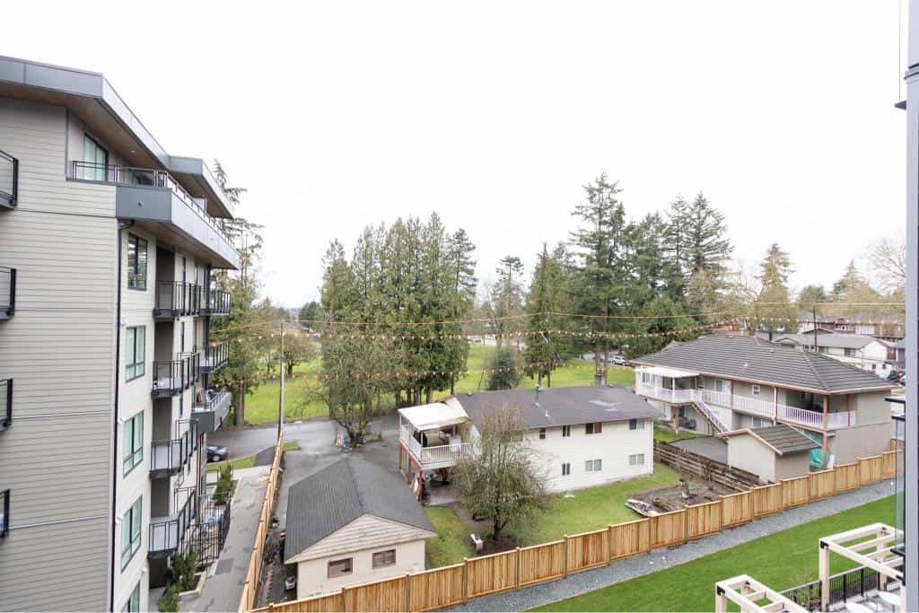 Modern apartment building overlooking green spaces and trees in a residential neighbourhood in Vancouver, BC. Perfect for prospective buyers seeking urban living with natural surroundings.