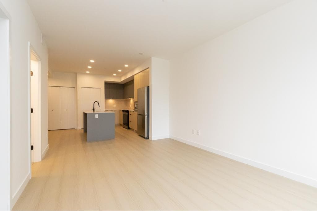 Spacious open-concept kitchen and living area in a modern condo, featuring light wood flooring and sleek cabinetry, ideal for Toronto real estate buyers.