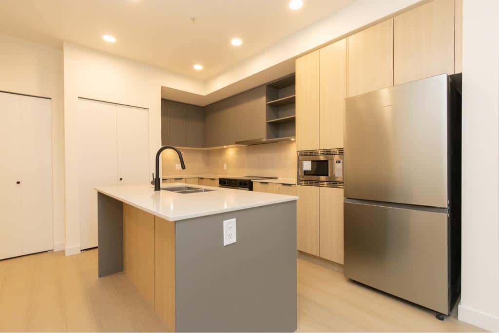 Modern kitchen with stainless steel appliances and minimalist design, ideal for Vancouver real estate buyers seeking contemporary homes.