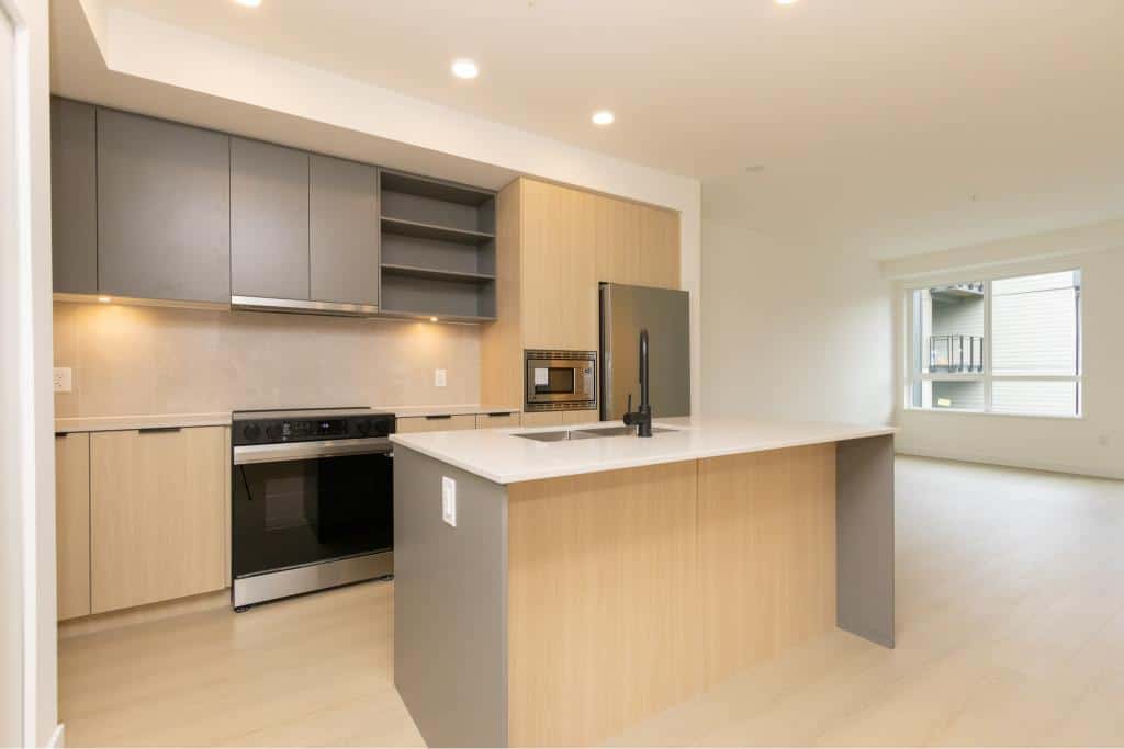 Modern kitchen with sleek cabinetry and stainless steel appliances in a contemporary condo, ideal for Vancouver real estate buyers seeking stylish, functional homes.