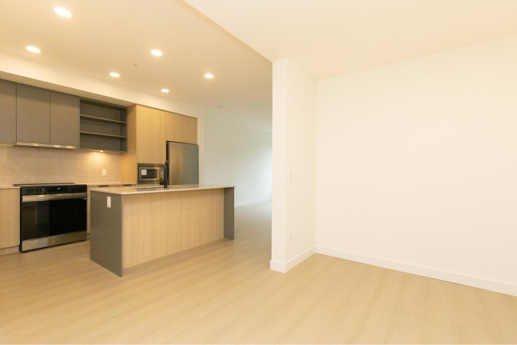Modern kitchen with stainless steel appliances and open living space in a contemporary condo. Perfect for Vancouver real estate investors and new homeowners. Bright, spacious, and move-in ready.