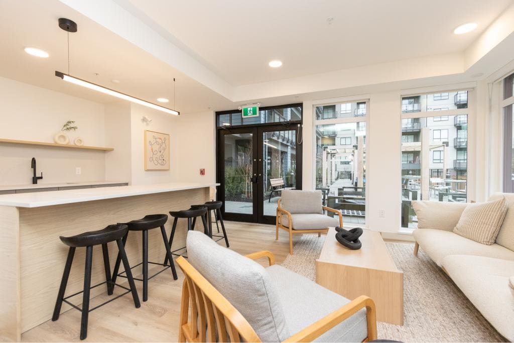 Bright modern living room with large windows, contemporary furniture, and a cozy seating area in a serviced apartment by Orca Realty Inc.