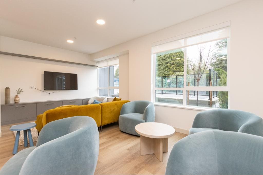 Modern condo living room with large windows, comfortable seating, and minimalist design in Vancouver, BC.