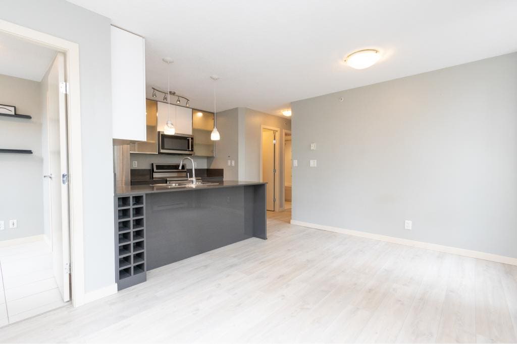 Modern open-concept kitchen in Vancouver condo showing sleek cabinetry and stainless steel appliances.