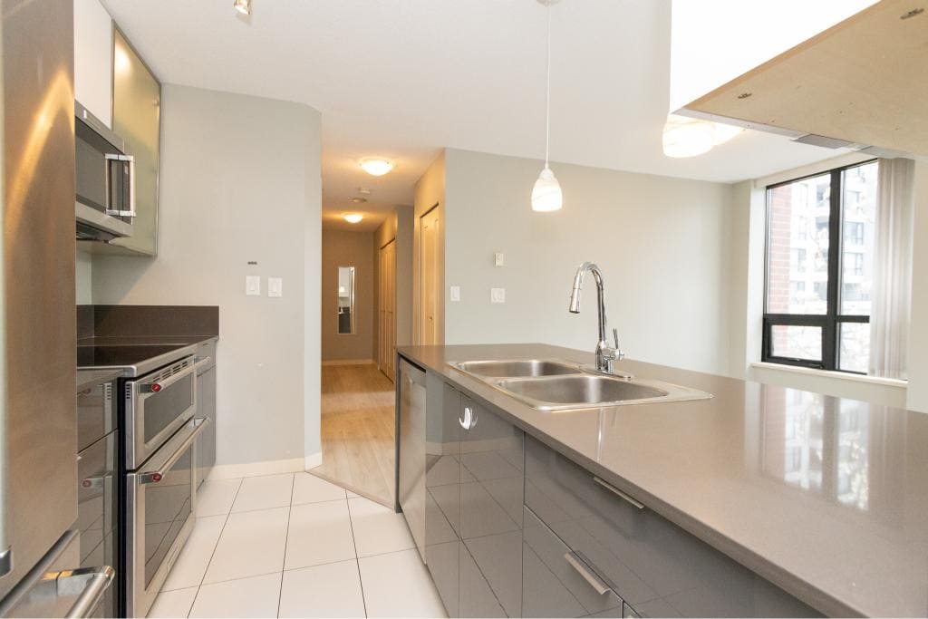 Modern kitchen with stainless steel appliances and granite countertops at Orca Realty Inc., Vancouver real estate.