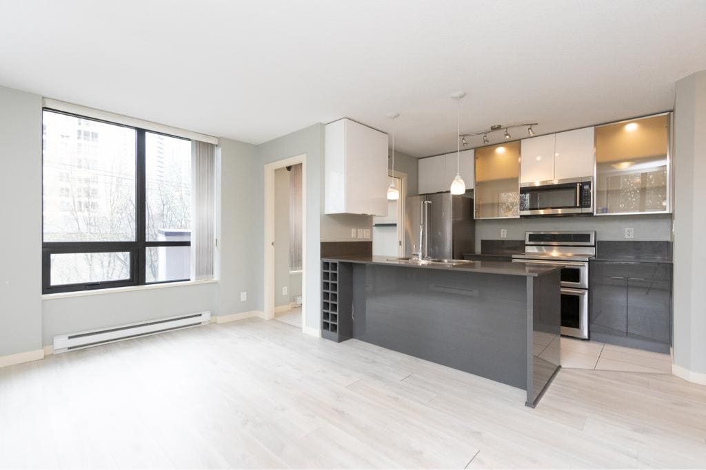 Modern open-concept kitchen in Vancouver condo with stainless steel appliances and sleek cabinetry.