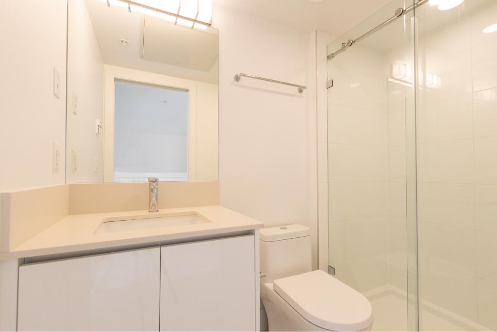 Bright modern bathroom with walk-in shower, white vanity, and minimalist design – perfect for Vancouver real estate listings.