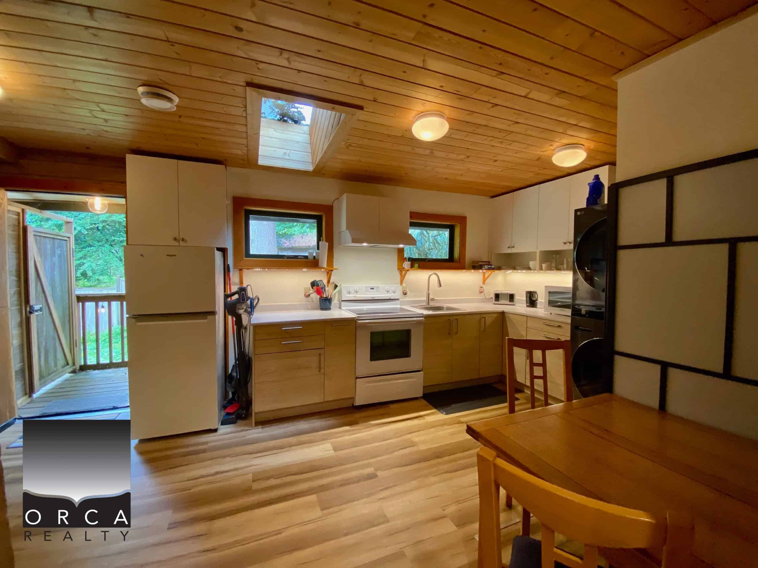 Cozy wooden kitchen with natural light, modern appliances, and a warm ambiance, perfect for family living or vacation rentals in Orca Realty listings.