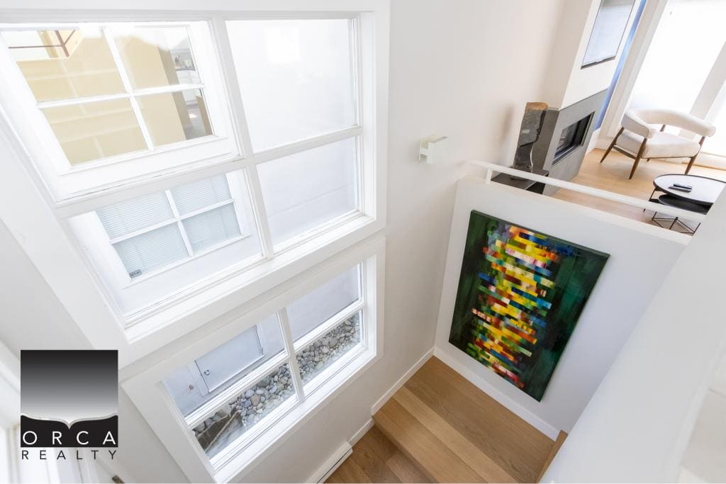Bright modern interior with large windows, contemporary artwork, and stylish furniture, showcasing upscale Vancouver residential real estate by Orca Realty Inc.