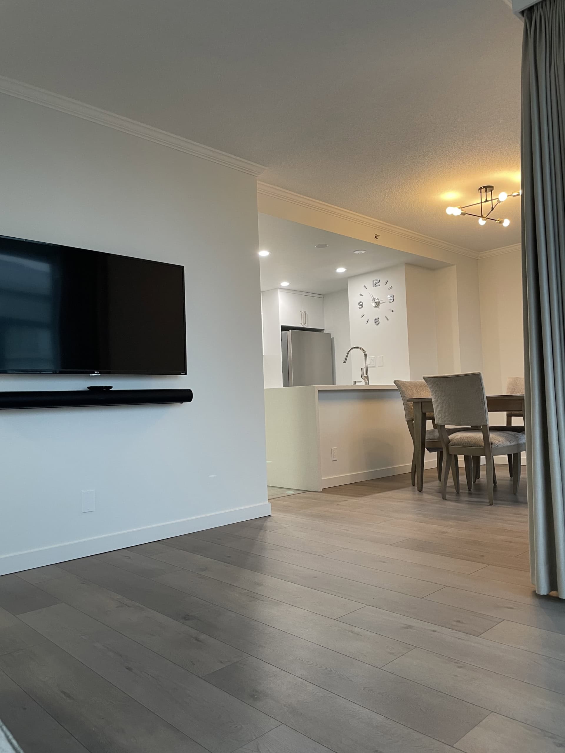 Modern condo interior with open living and dining area, kitchen with stainless steel appliances, and hardwood flooring, offered by Orca Realty Inc. in Vancouver. Perfect for prospective homeowners and real estate investors.