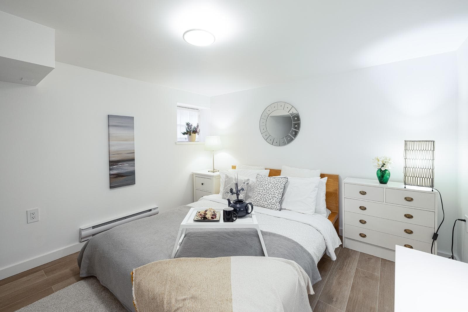Bright modern bedroom with white walls, minimalist decor, and natural light, showcasing Prime real estate listings by Orca Realty Inc. in a cozy, stylish home setting.